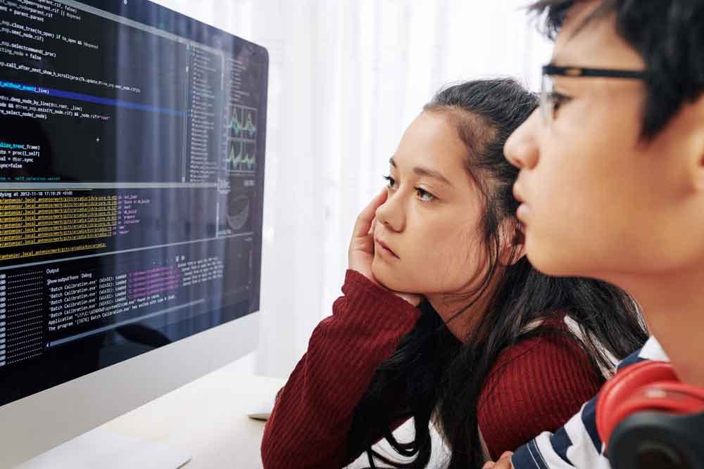 Students looking at code on a computer